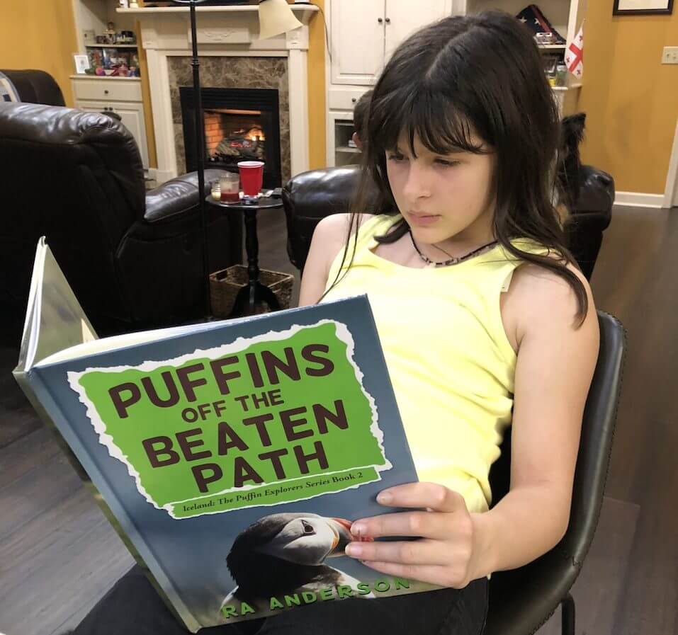 Payton reading Puffins Off The Beaton Path by RA Anderson
